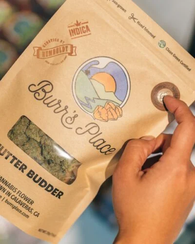 hands holding burr's place nutter budder cannabis packaging