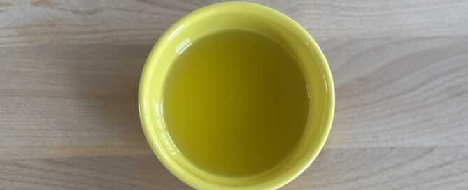 cannabis oil for cooking in a yellow container on a wood cutting board
