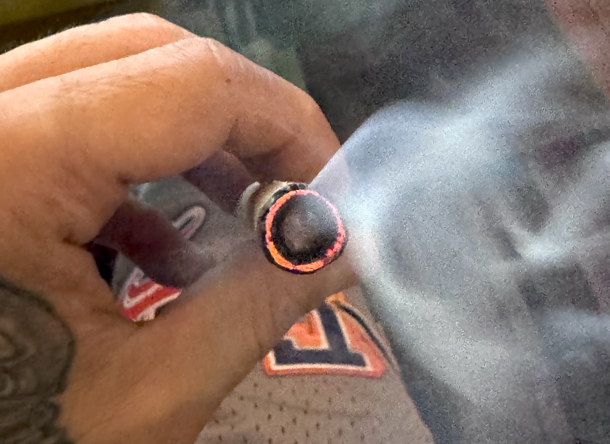 burning hash hole smoking donut joint in man's hand between fingers