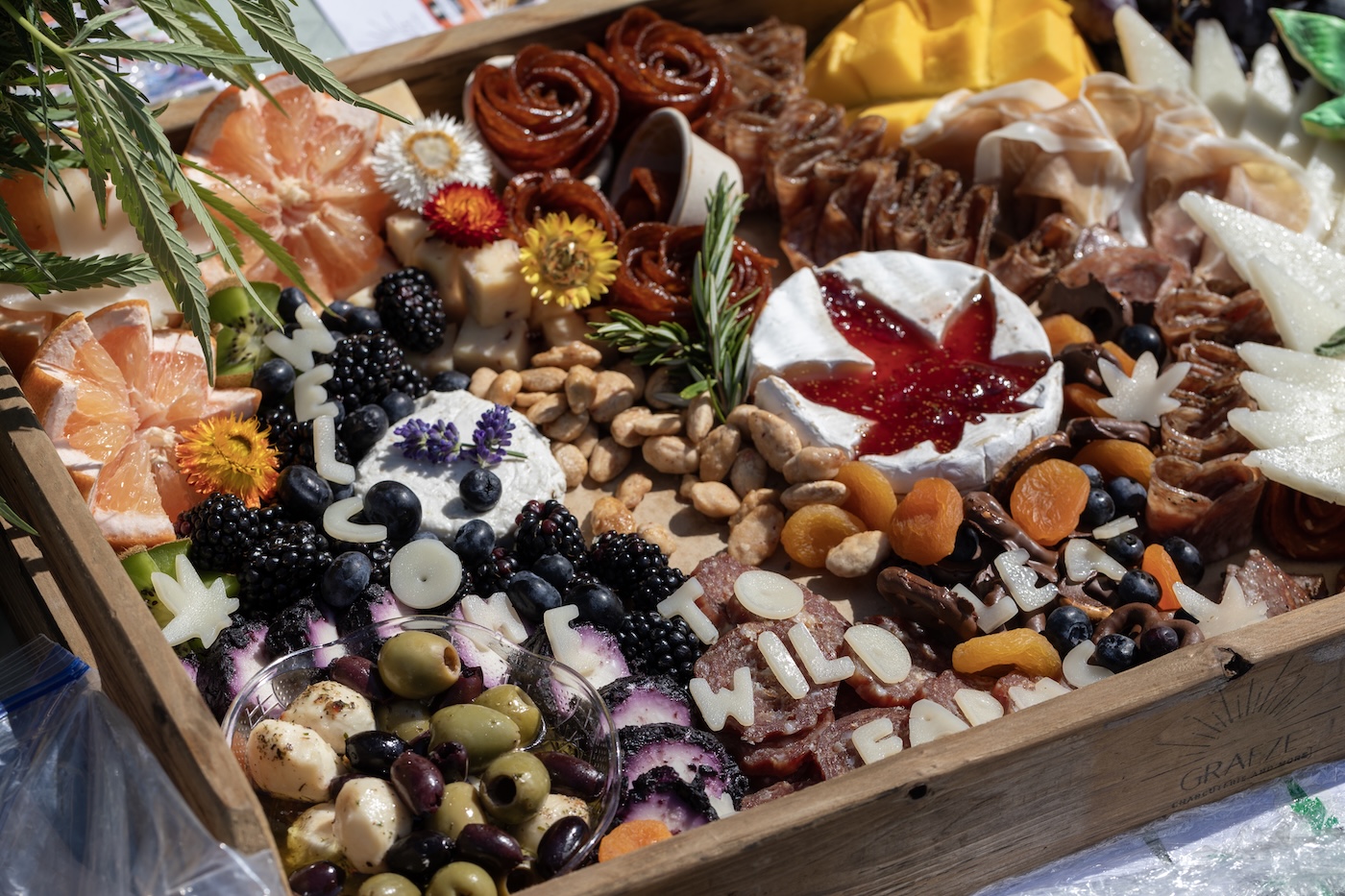 cannabis charcuterie with infused jam in cheese with fruits and nuts on a wooden board