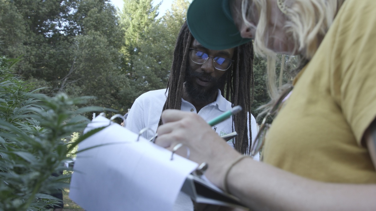 homme et femme prenant des notes sur une ferme de cannabis en vue d'une chasse au phénotype