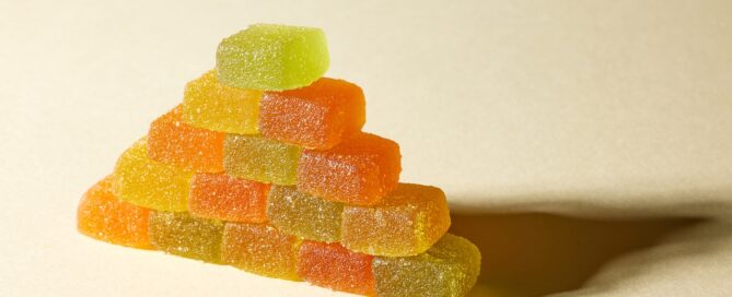 homemade cannabis gummies stacked in a triangle with red, green, yellow, and orange weed gummies