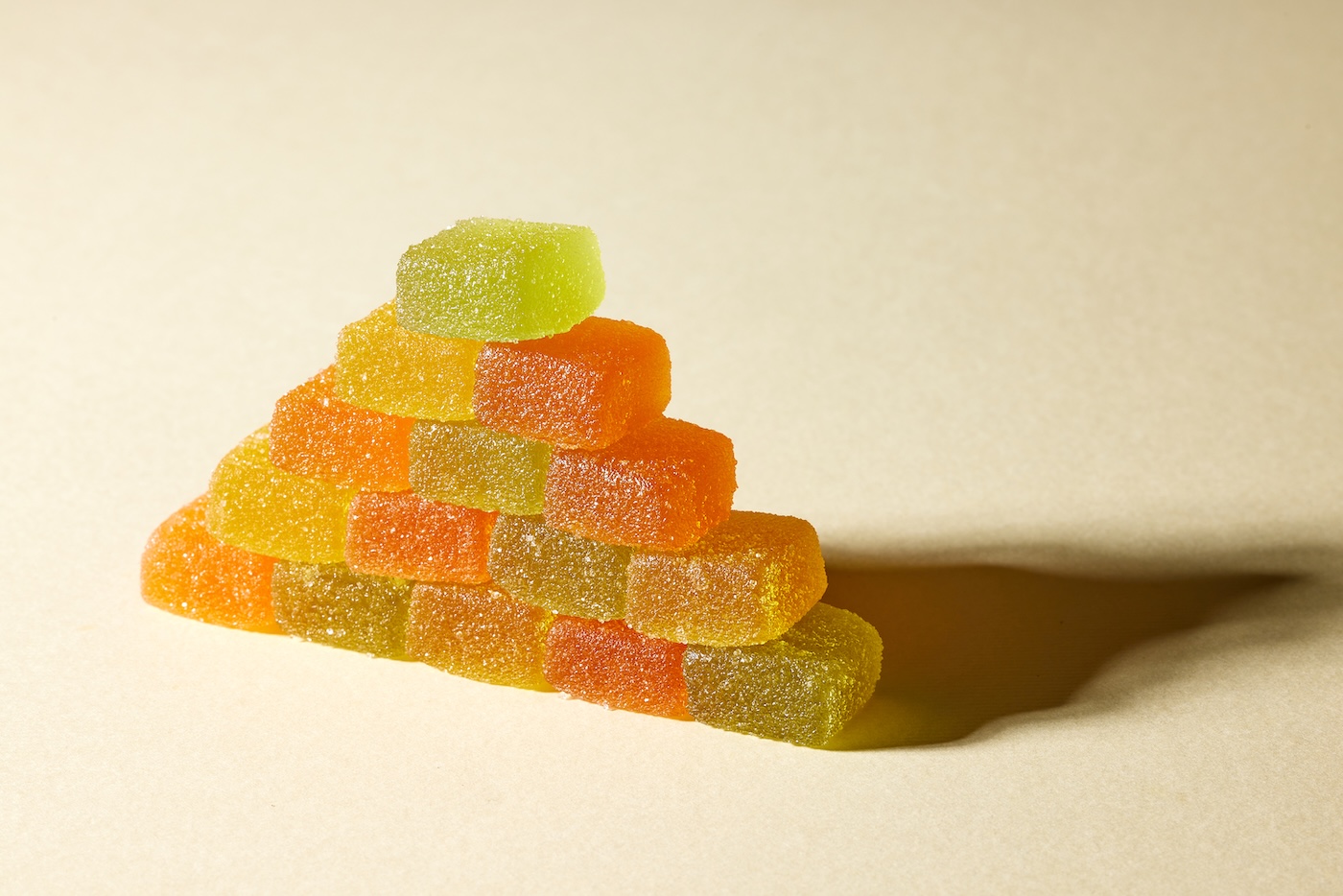 zelfgemaakte cannabis gummies gestapeld in een driehoek met rode, groene, gele en oranje wiet gummies