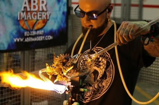 Finnish glass artist PolteGlass working with an open flame on a new dragon head glass piece 