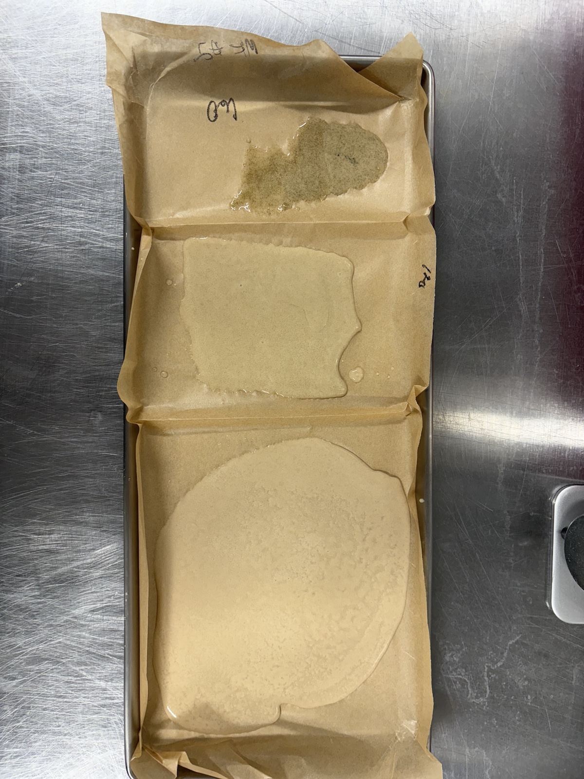three grades of ice water hash on a tray with parchment paper