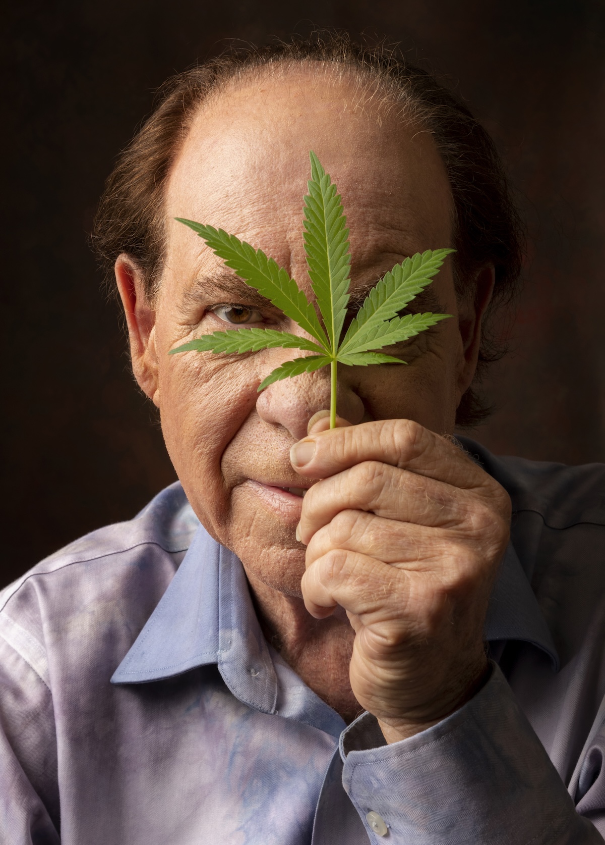 Ed Rosenthal holding a Cannabis Leaf in front of his face