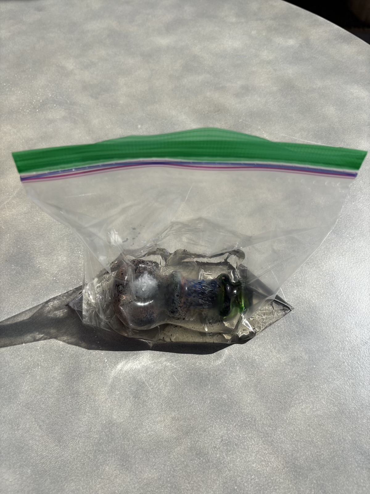 een vuile pijp die in rijst met grof zout en isopropylalcohol ligt te weken om hem schoon te maken