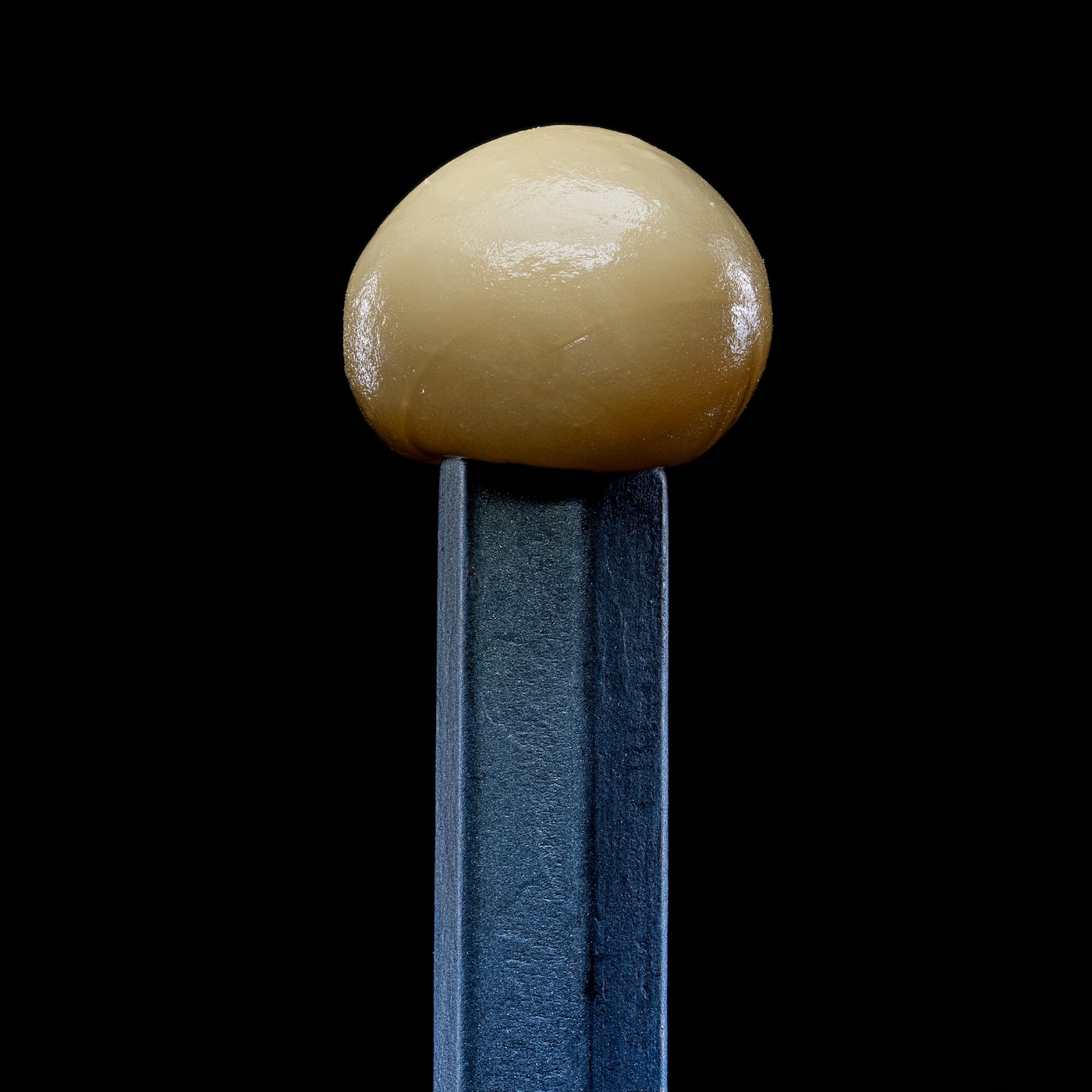 close-up van een bolletje hasjhars op een zwarte achtergrond