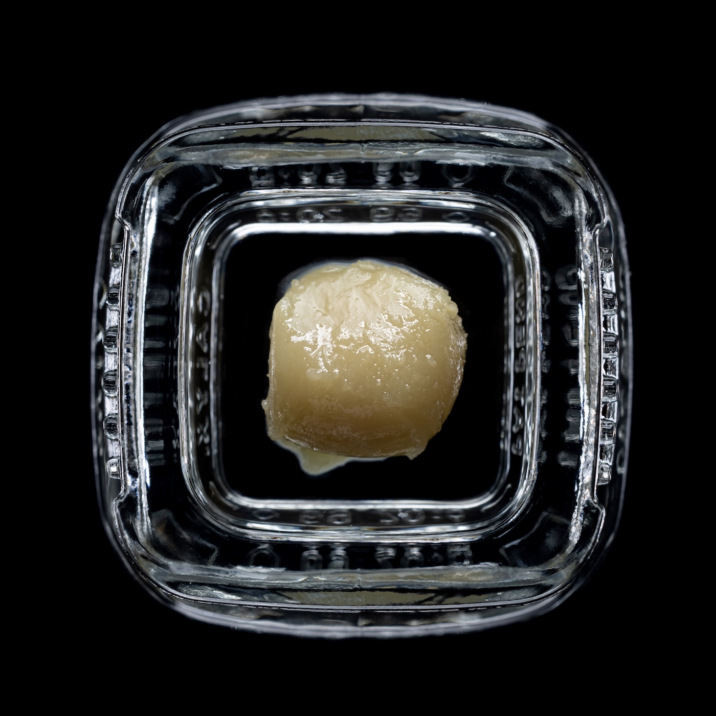 Hoogwaardige cannabishars in een doorzichtige pot op een zwarte achtergrond