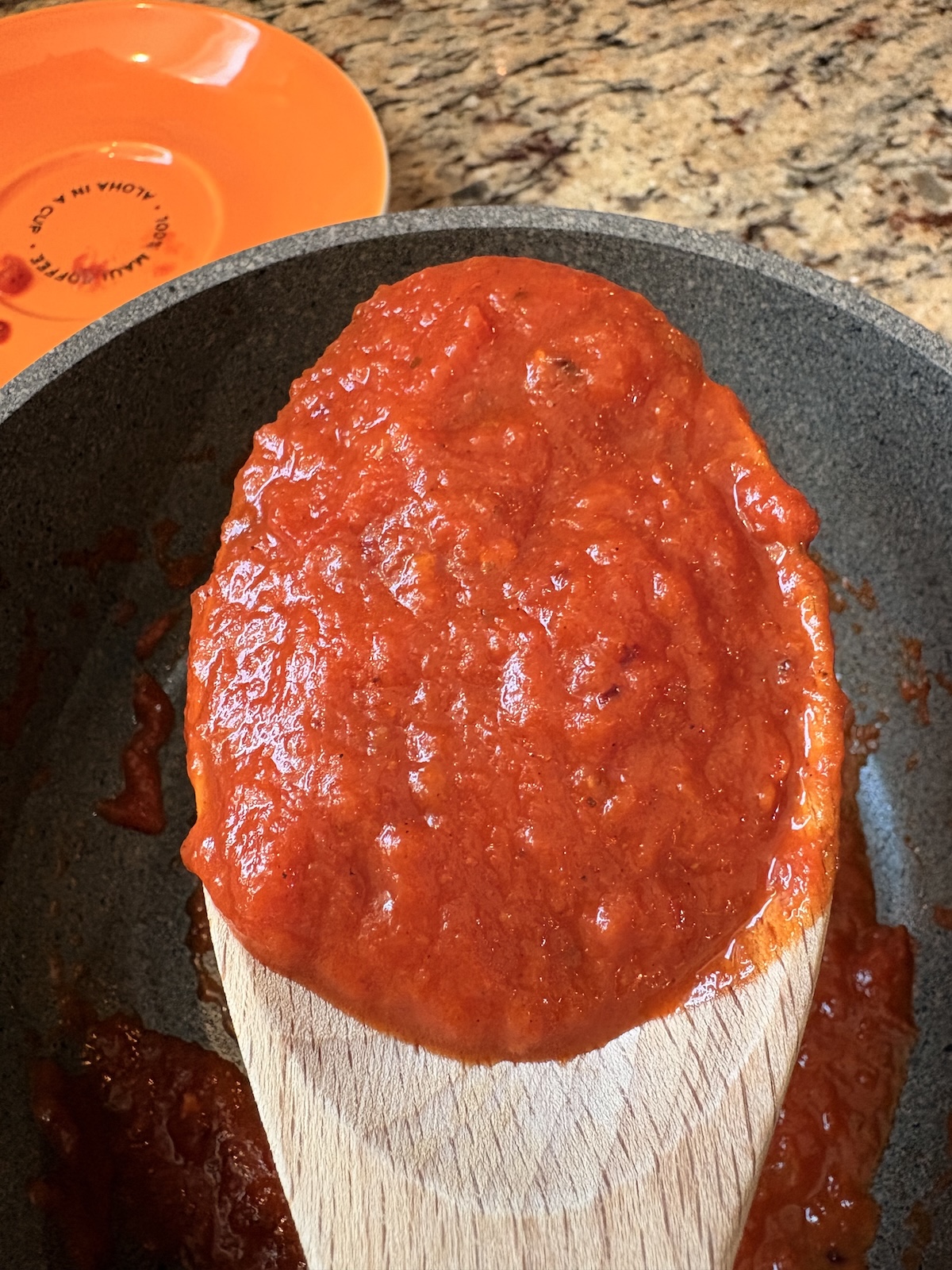 San Marzano Tomato Sauce on wooden spoon over pot