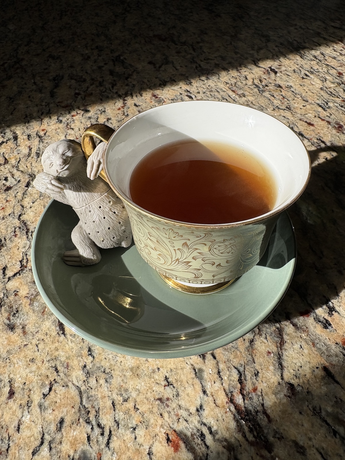 chá de calêndula com infusor em forma de preguiça numa xícara de chá de porcelana japonesa